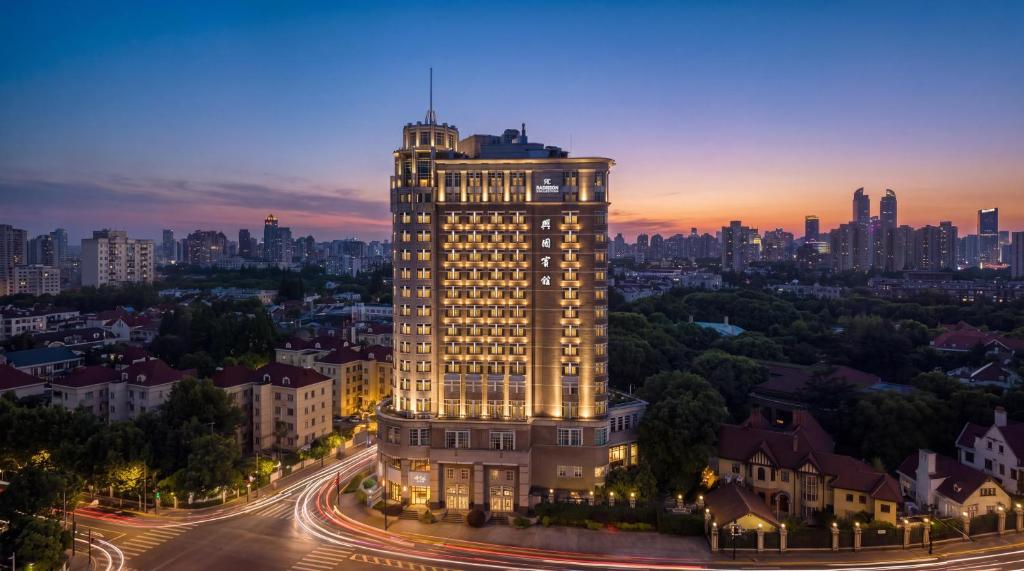 a lit up building with a city in the background at Radisson Collection Hotel, Xing Guo Shanghai in Shanghai