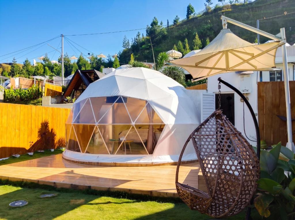 a dome tent in a garden with a fence at Maple Dome Glamping in Bandung