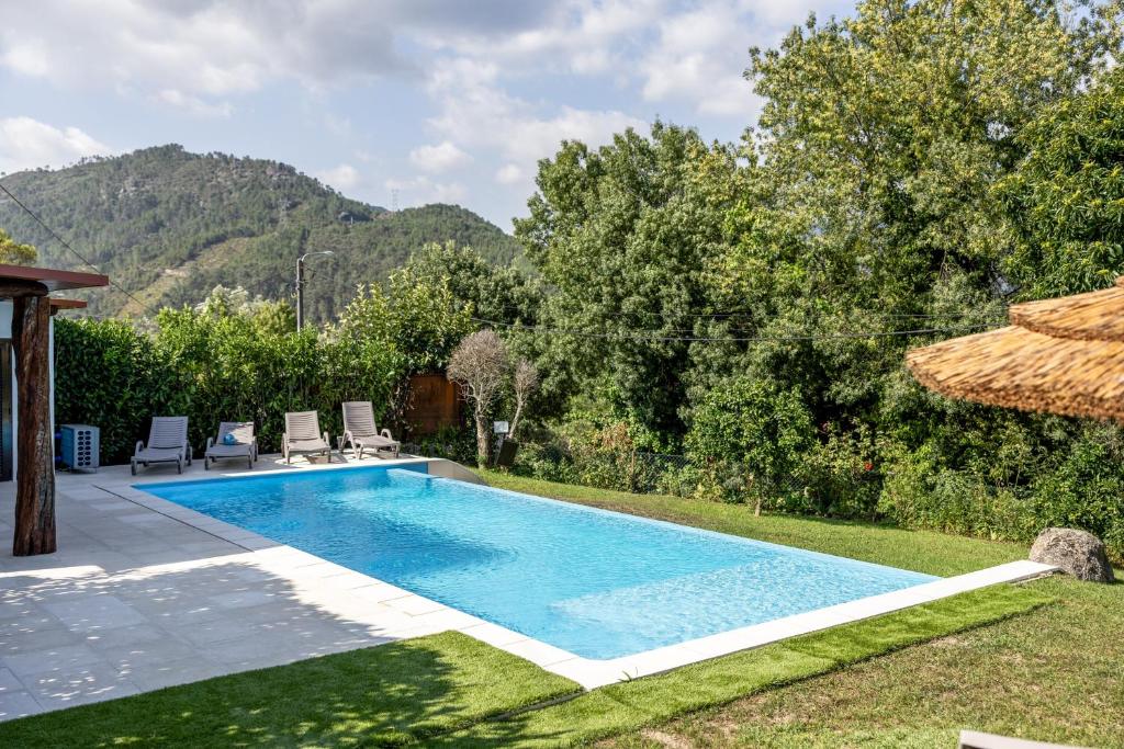 a swimming pool in a backyard with a villa at Refúgio da Nelinha in Rio Caldo