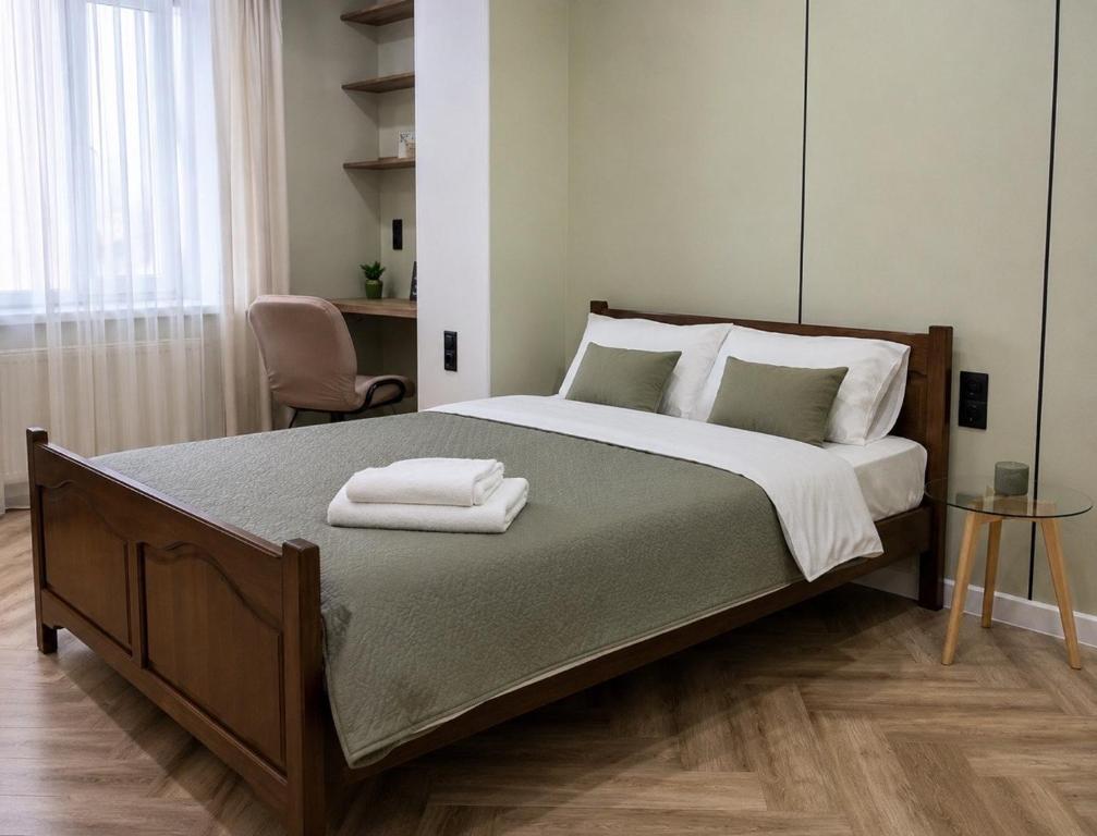 a bedroom with a large bed with two towels on it at Modern Olive Home in Căuşeni