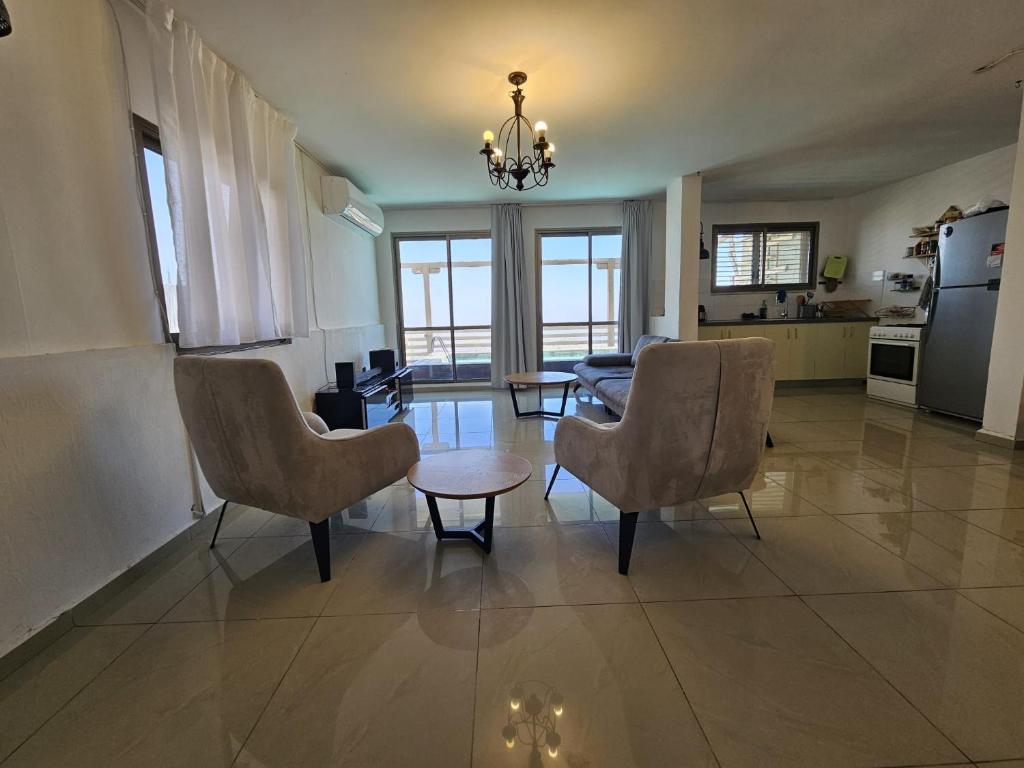 a living room with two chairs and a table at Kinneret view with pool in Safed