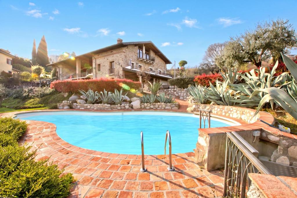 a swimming pool in front of a house at Agriturismo Cascina Crocelle - Lake View and Heated Pool in Padenghe sul Garda