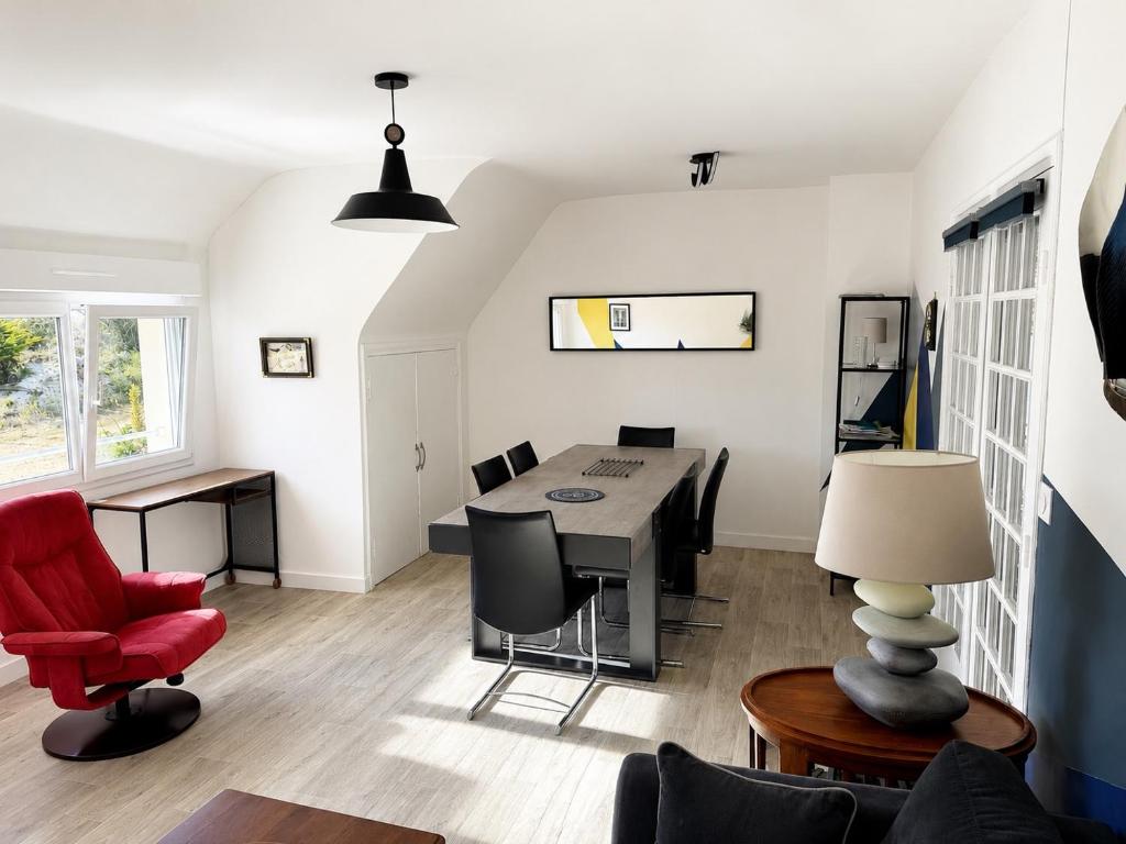 a living room with a table and a red chair at An Dorzell beach 60 meters in Cléder