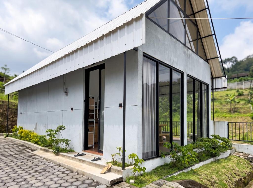 a white house with large windows and a driveway at Private Cabin in Bandung