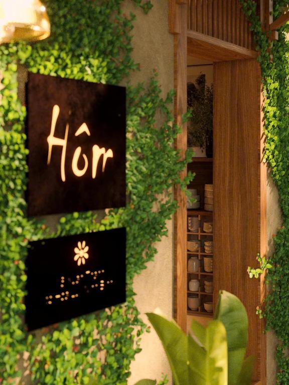 a sign on the side of a building with plants at Châu Home in Ninh Binh