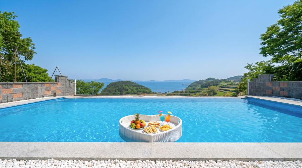 a bowl of fruit in a boat next to a swimming pool at Namhae U9Stay in Namhae
