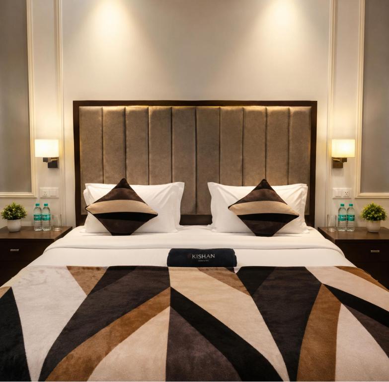 a bedroom with a large bed with black and white pillows at SoulStay Vrindavan in Mathura