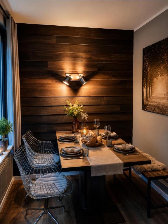 a dining room with a wooden wall with a table and chairs at Bungalow Uhu mit Aussensauna in Lage