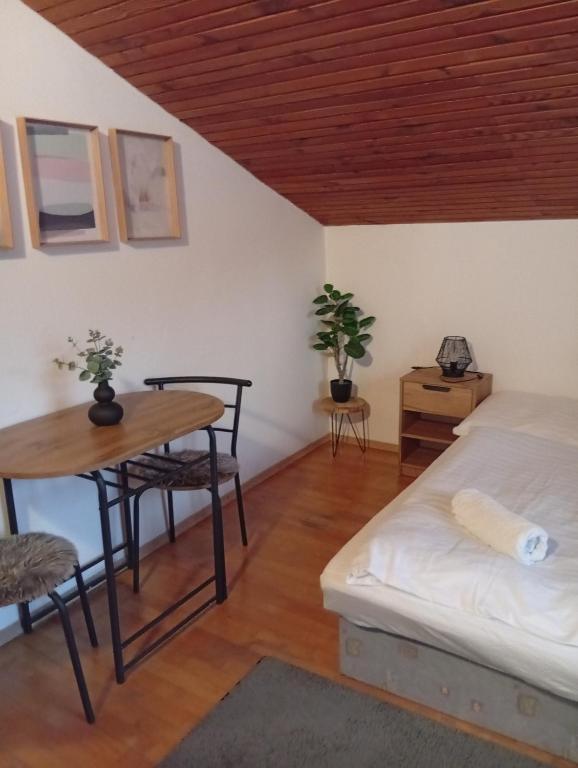 a bedroom with a bed and a table and a desk at Penzion Helena in Stará Lesná