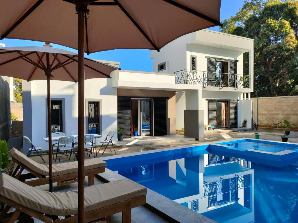 a villa with a swimming pool and a house at Residence Meva Soa Majunga in Amborovy