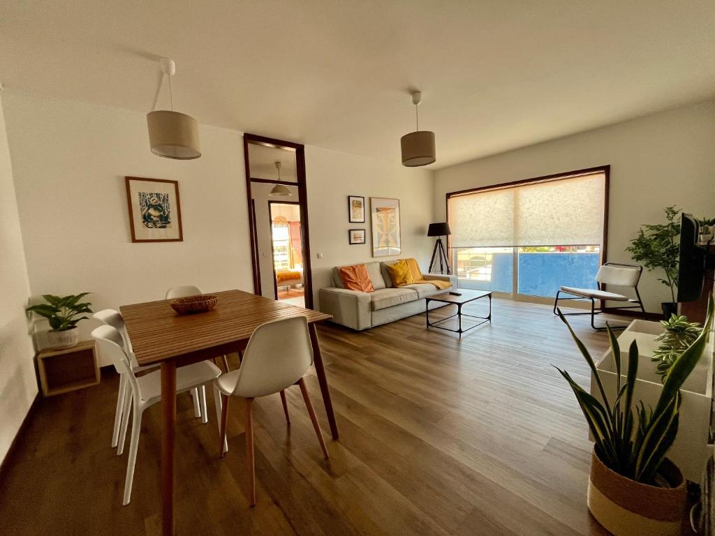 a living room with a table and a couch at Onda Beach House in Cortegaça