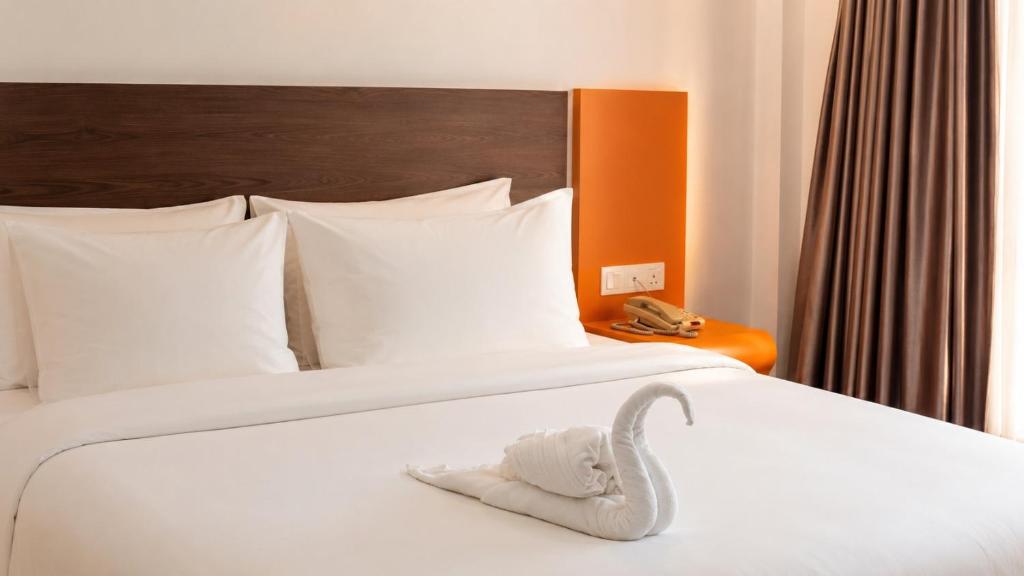 a pair of white beds in a hotel room at Kingston Hotel 22 - Cheras, Kuala Lumpur in Kuala Lumpur