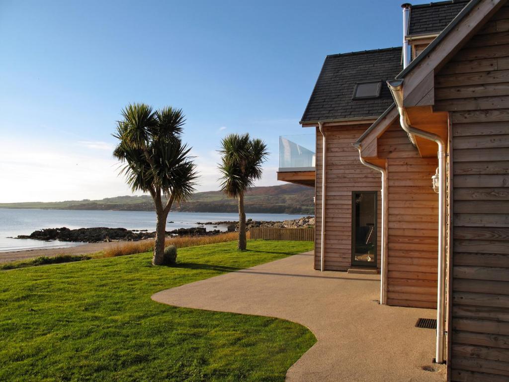 a house with a walkway next to a beach at Airds Bay Luxury Beach House in Gatehouse of Fleet