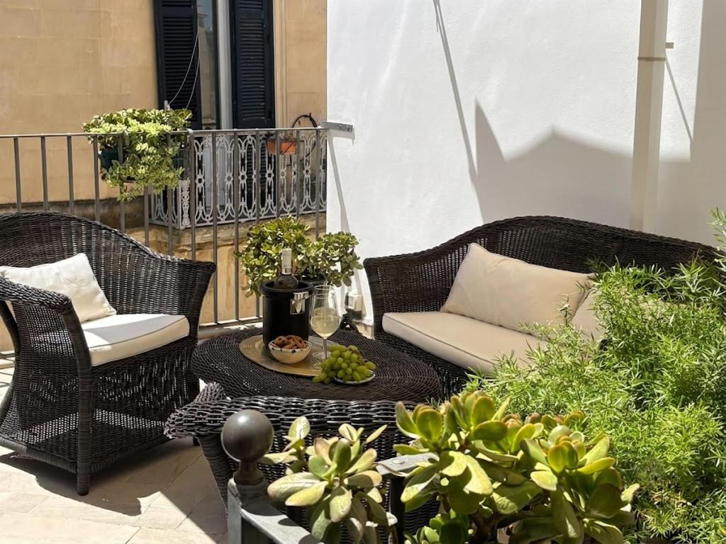 a patio with two wicker chairs and a table at Biccari 6 Terrace Apartament in Lecce