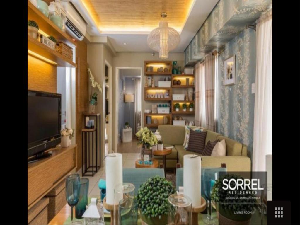a living room with a couch and a tv at Sorrel Residences Condo Apartment by Fe in Manila