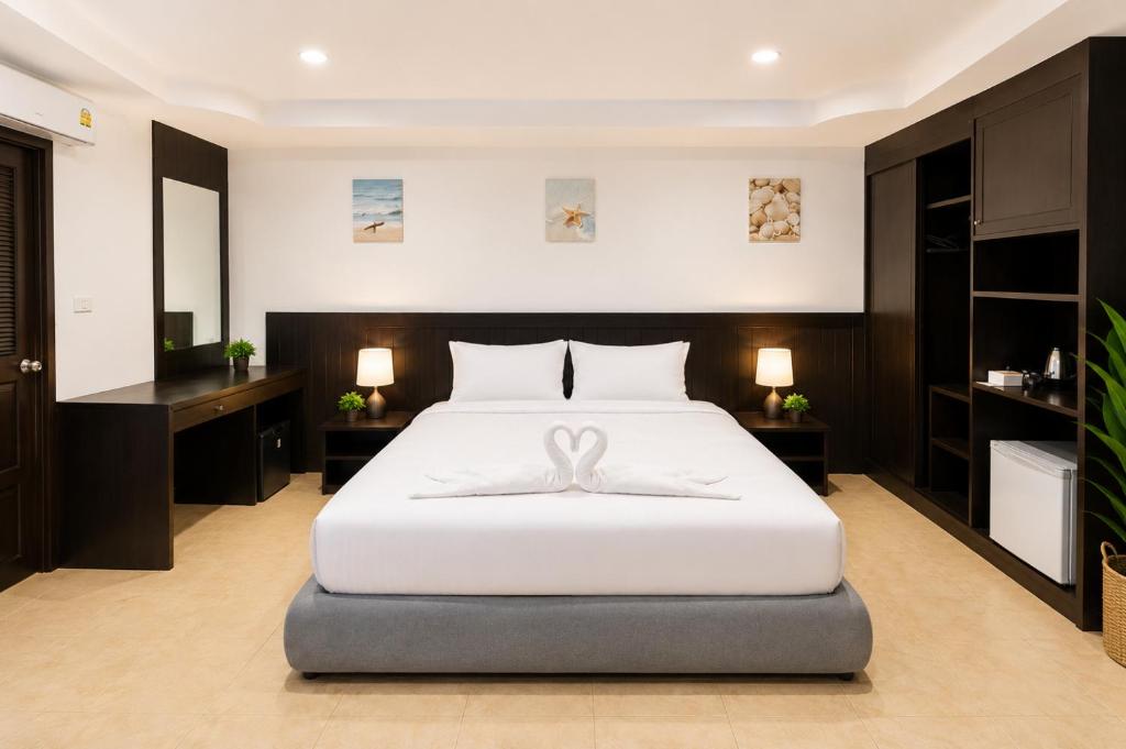a bedroom with a large white bed with a ribbon on it at Hill Side Patong in Patong Beach