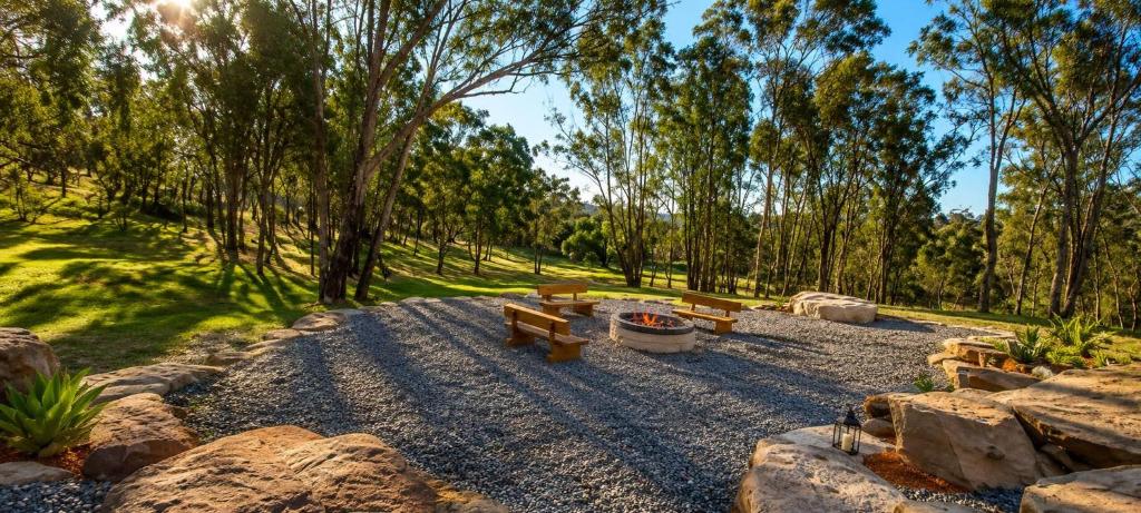 a park with benches and rocks and trees at Willow Cabin at The Reset Retreat in Charbon