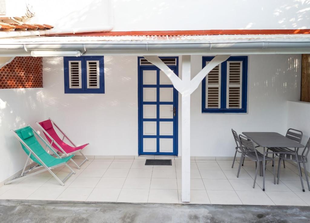 a patio with chairs and a table on a house at Appartement cosy Le Marin 60 m² + jardin in Le Marin