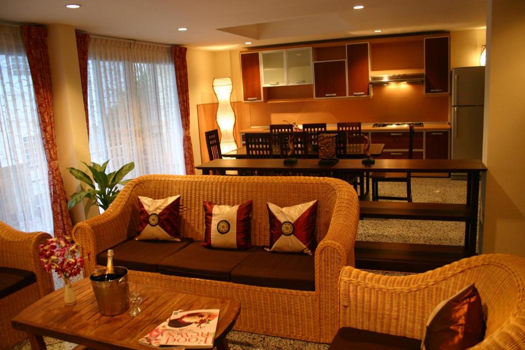 Una sala de estar con un sofá y una cocina. en Tolmaj Family Apartment, en Ao Nang Beach