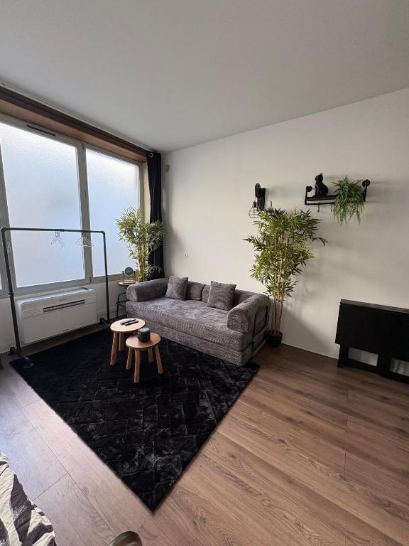 a living room with a couch and a table at Chill & Play in Casteljaloux
