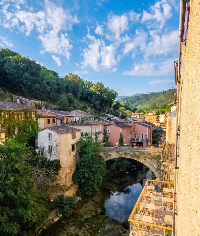 a bridge over a river in a town at Studio confortable, Rennes les bains, 17 m² + Balcon in Rennes-les-Bains