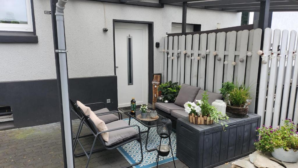 a patio with a couch and a table and a fence at Ferien-, Monteurswohnung in Bottrop in Bottrop