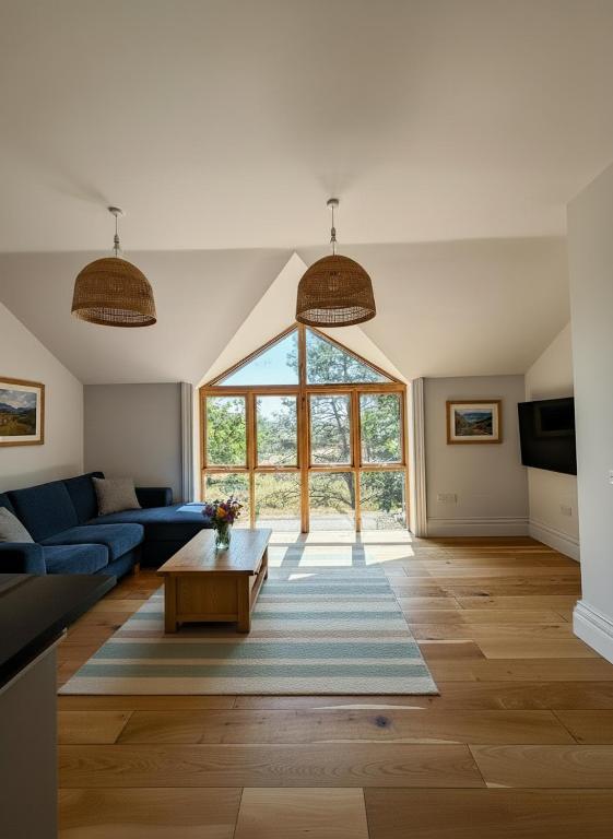 a living room with a blue couch and a large window at Cymyran Terrace in Holyhead
