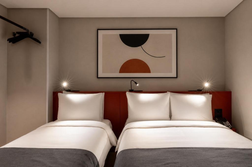 two twin beds in a room with a painting at Best Western Insadong Hotel in Seoul