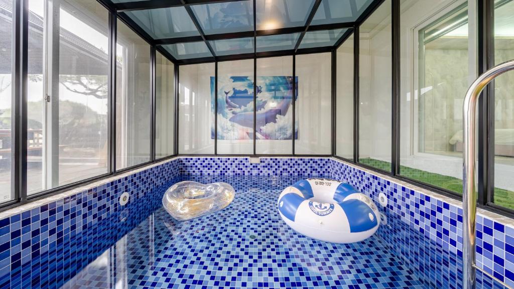 a bathroom with a blue and white tiled tub at Chuncheon Poolhouse Epop in Chuncheon