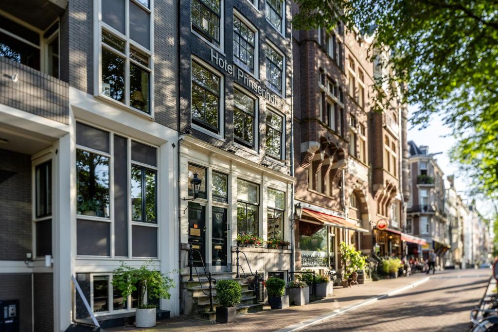 a building on a city street with potted plants at Hotel Prinsenhof Amsterdam in Amsterdam