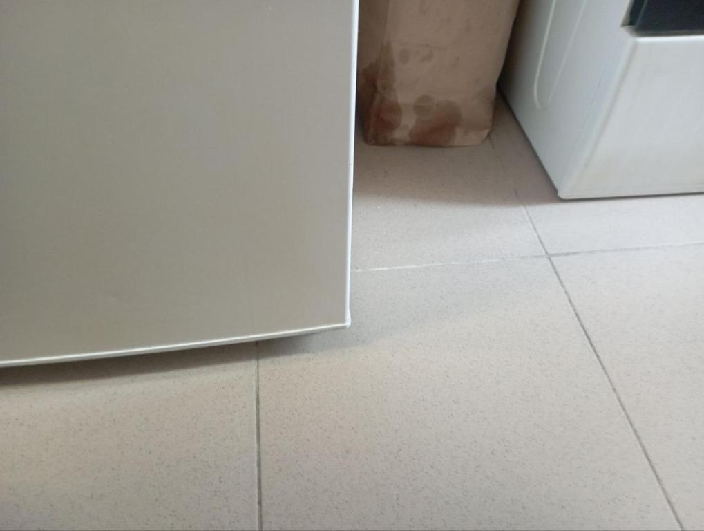 a white tiled floor in a kitchen with a white refrigerator at Lieu inoubliable in Monte Carlo