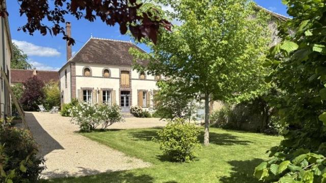 a large white house with a tree in the yard at Gite Les Robins in Rebourseaux