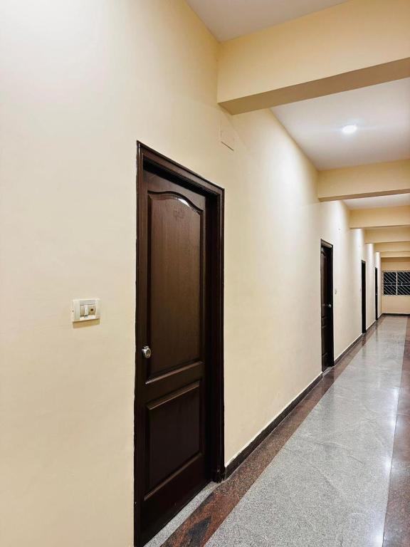 a hallway with a black door in a building at Sahara Residency Mysore in Mysore