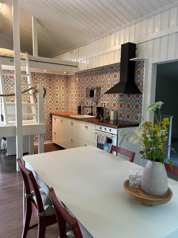 a kitchen with a white table and chairs in a room at 'Ekhaga Cabins' Lillestugan in Viddviken