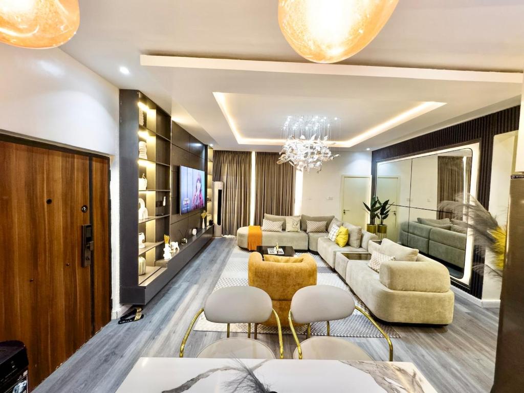 a living room with a couch and a table and chairs at Luxury 2BR Oasis in Lekki