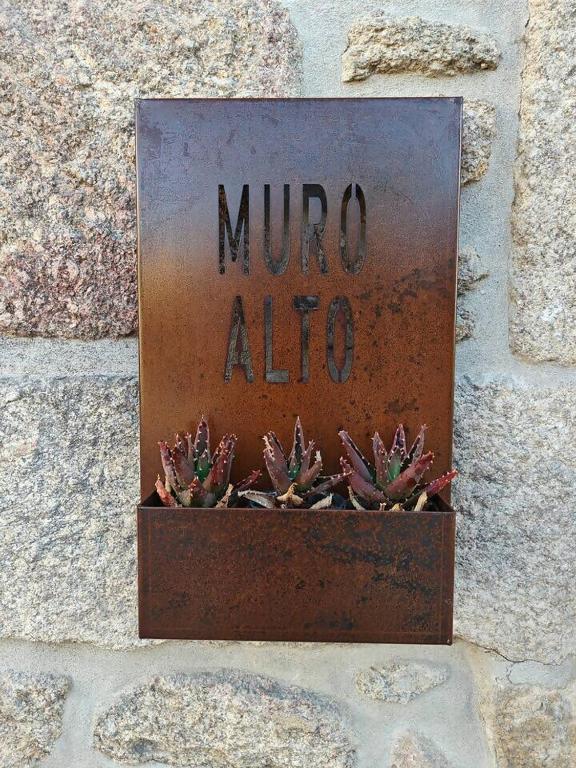 a sign that says minto alico on a stone wall at Casa do Muro Alto in Alvelos