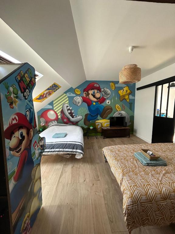 a bedroom with a mickey mouse mural on the wall at Super Mario Studio ! in Jaunay-Clan