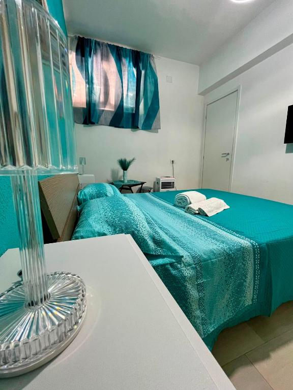 a room with a bed with a blue blanket and a table at B&B Tribale in Ercolano