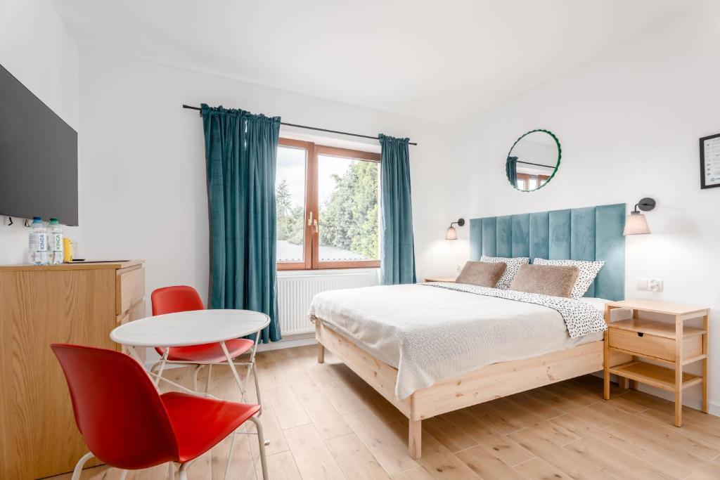 a bedroom with a bed and a table and chairs at Enjoy! Piaseczno in Piaseczno