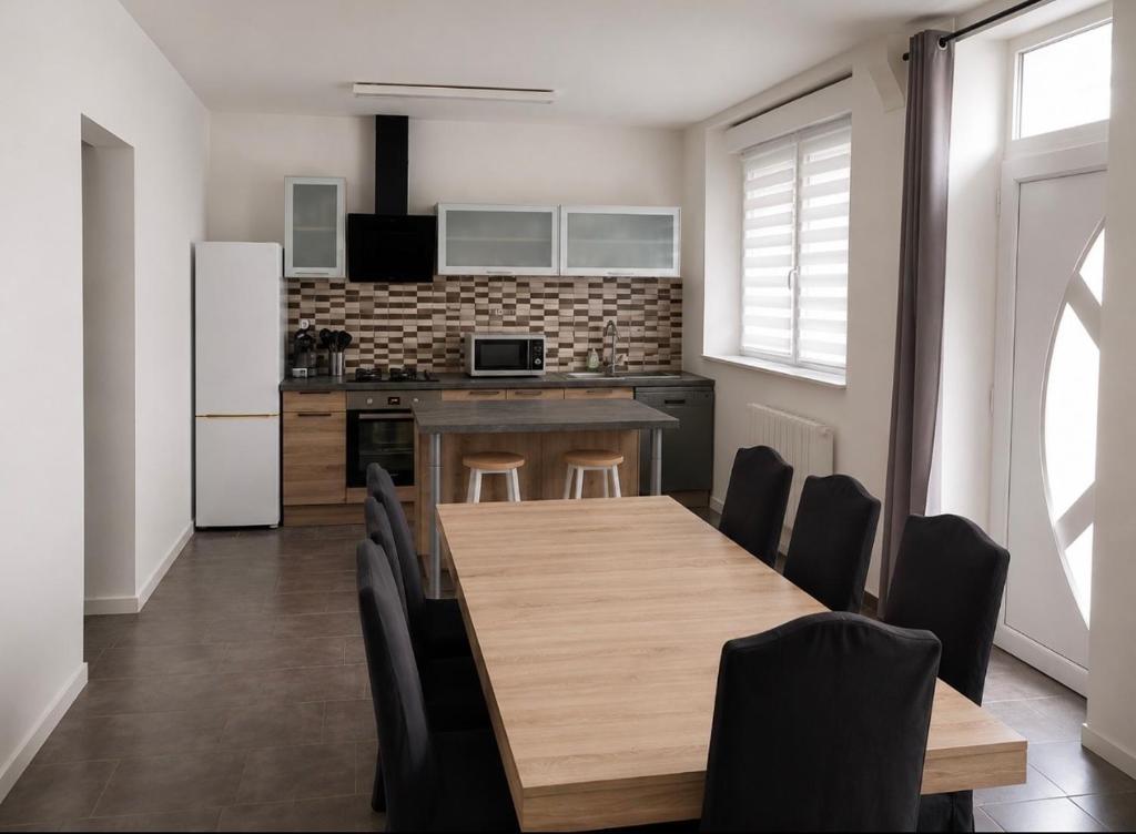 una cucina con tavolo di legno e sedie nere di Worgot a Monthermé