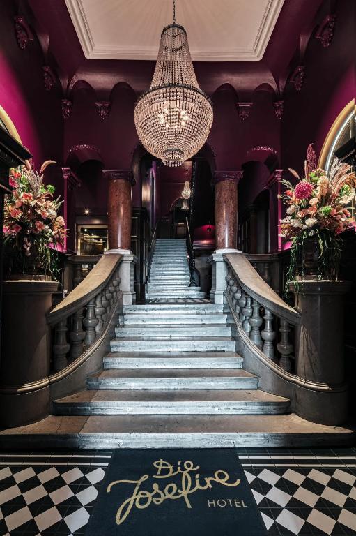 a staircase in a hotel with a chandelier at Eurostars Josefine in Vienna