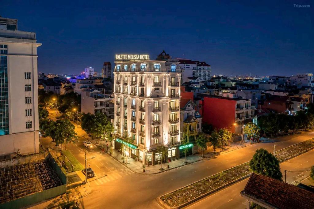 a lit up building in a city at night at Palette Melissa Ninh Binh - Near Hoa Lu Ancient Town in Ninh Binh