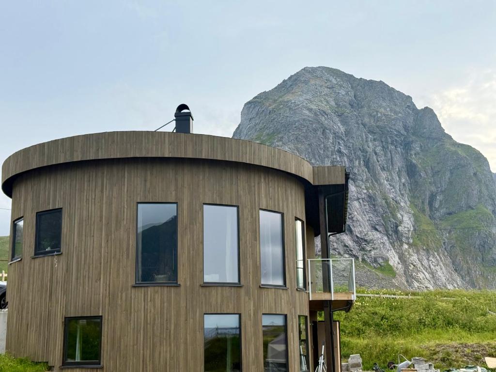 a round house with a mountain in the background at Flakstad beach house Silo B in Vareid
