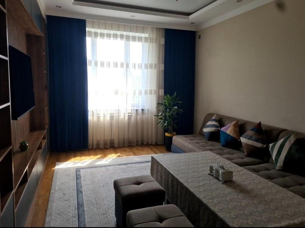 a living room with a couch and a table at Afsona in Namangan