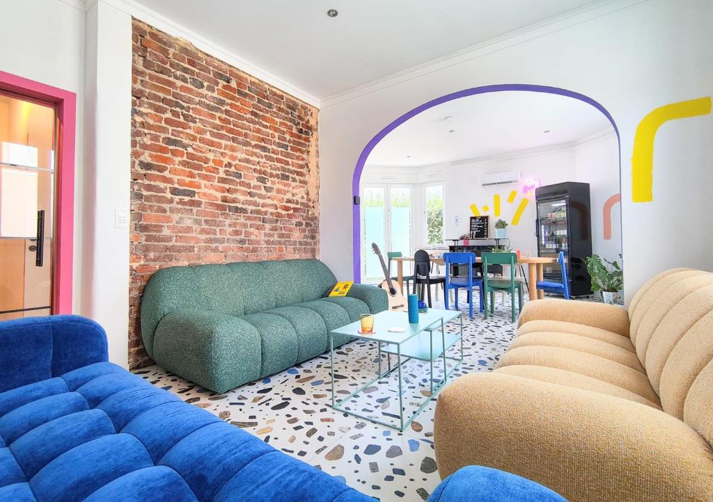 a living room with blue couches and a brick wall at Cool Cool House in Liège