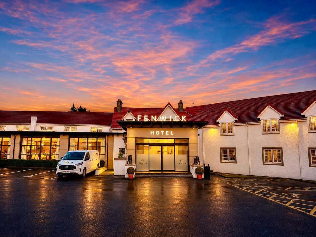a hotel with a car parked in a parking lot at The Fenwick Hotel in Kilmarnock