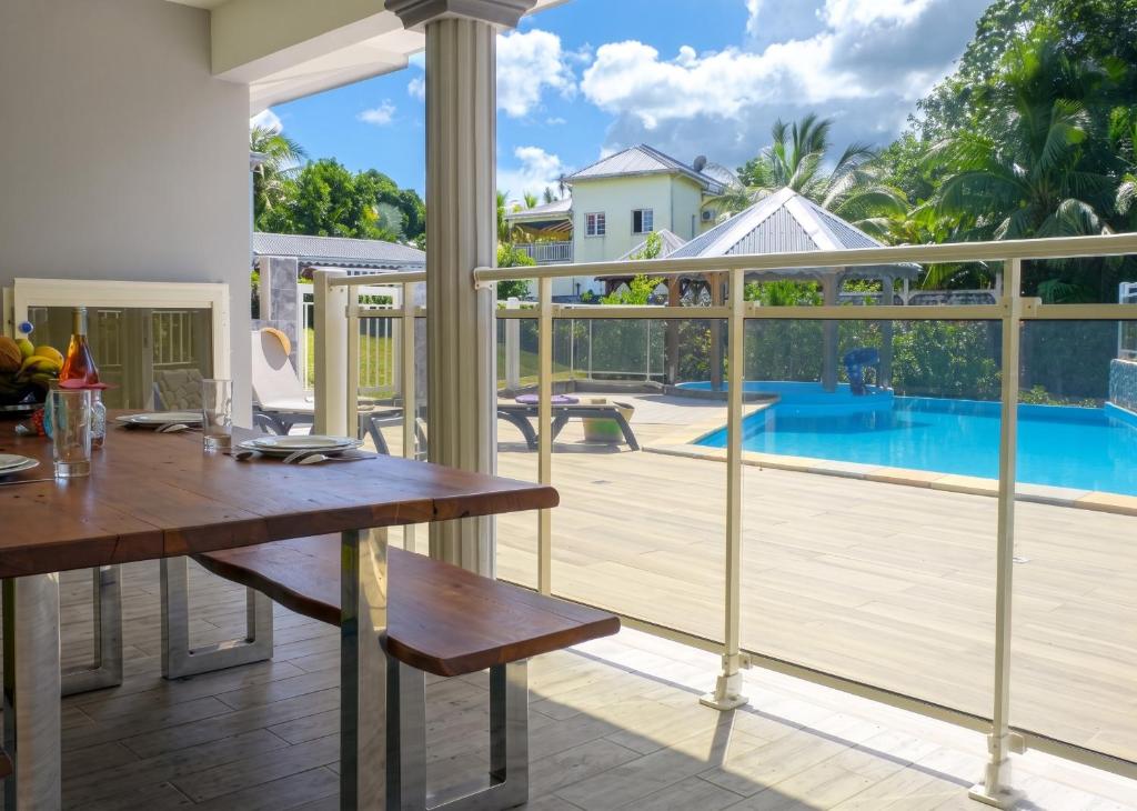 a dining room with a table and a view of a pool at Appartement spacieux avec jardin et piscine à Lamentin, 97 m² in Lamentin