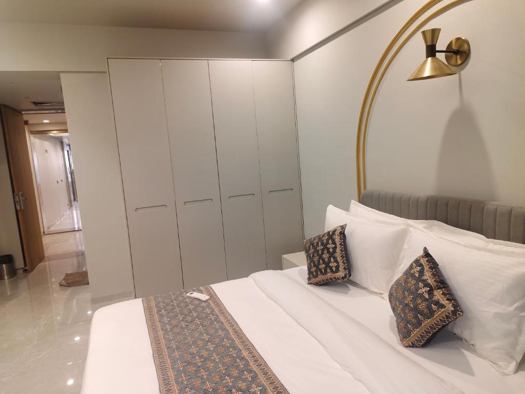a bedroom with a white bed with two pillows at Umbrellaa Hotels in Ahmedabad