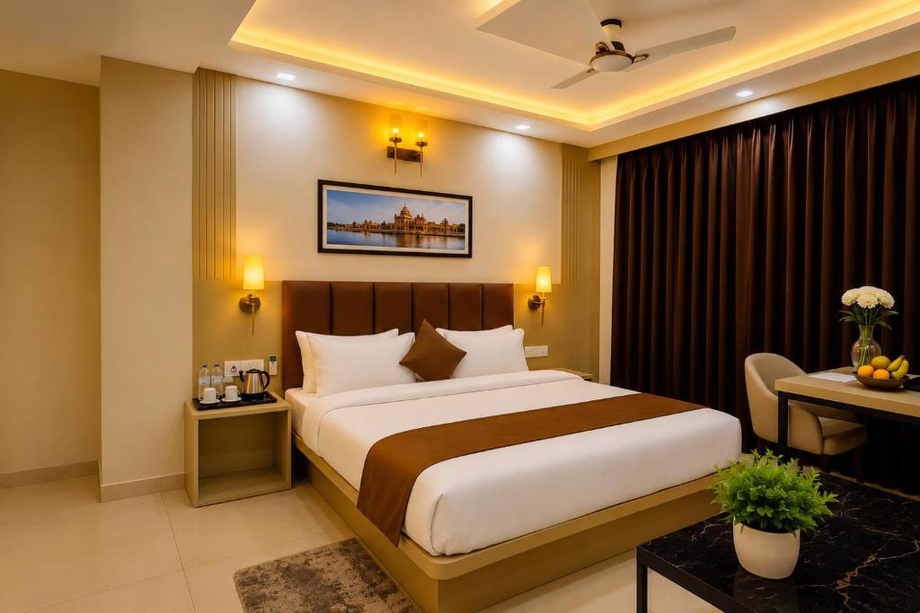 a hotel room with a large bed and a desk at Hotel Vasudevay Inn in Haridwār