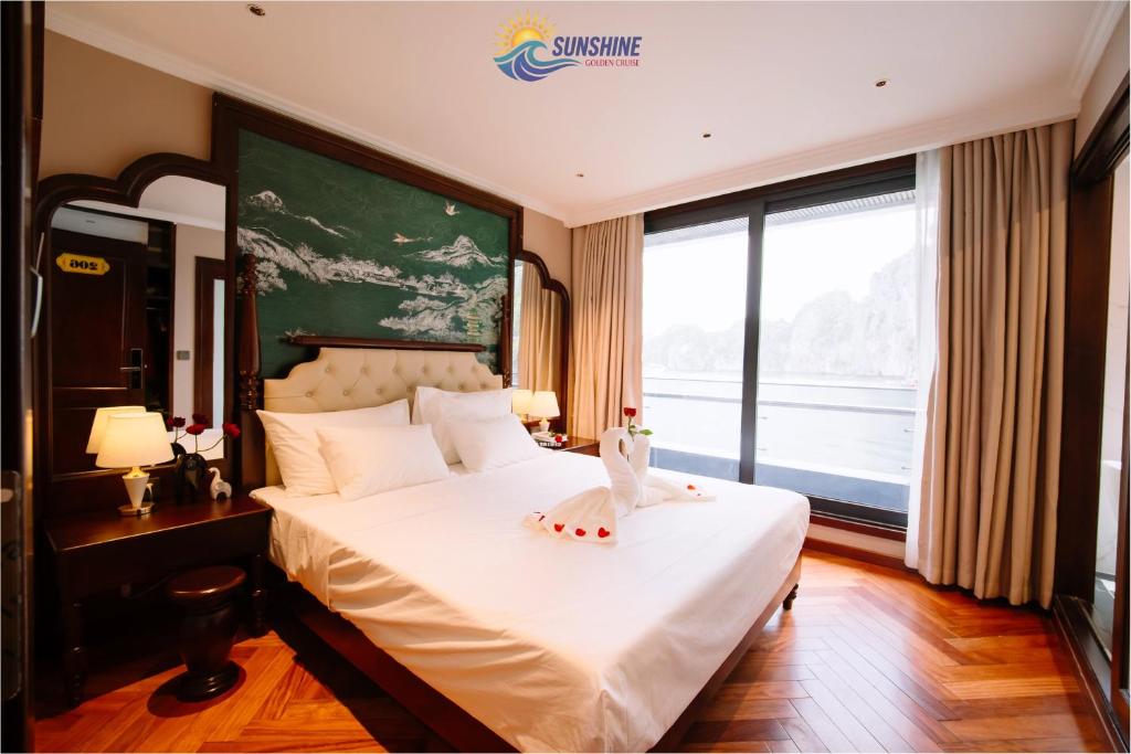 a bedroom with a large bed with a large window at Sunshine Golden Cruises in Cat Ba